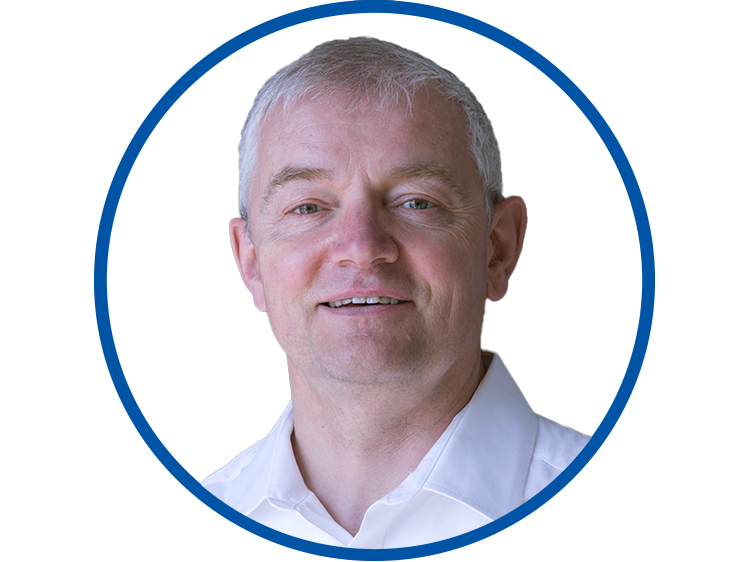 Circular headshot of MArkus Schaufele with a blue border. Markus has light skin, light eyes, and short white hair, and is wearing a white shirt.