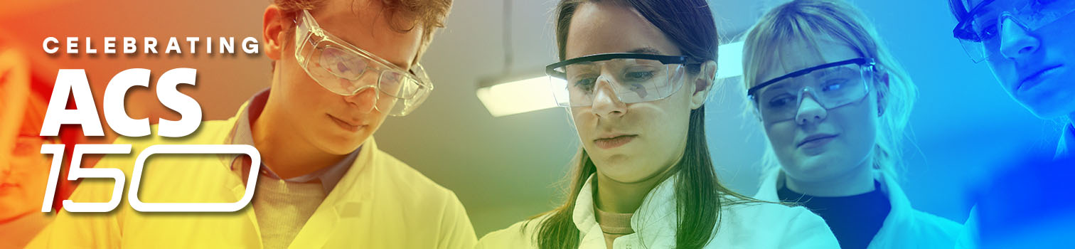 Assistant lecturer supervising female student, all wearing lab coats and protective workwear in class